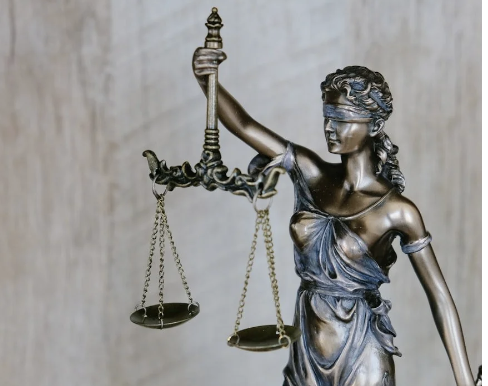 Bronze statue of Lady Justice holding balanced scales.
